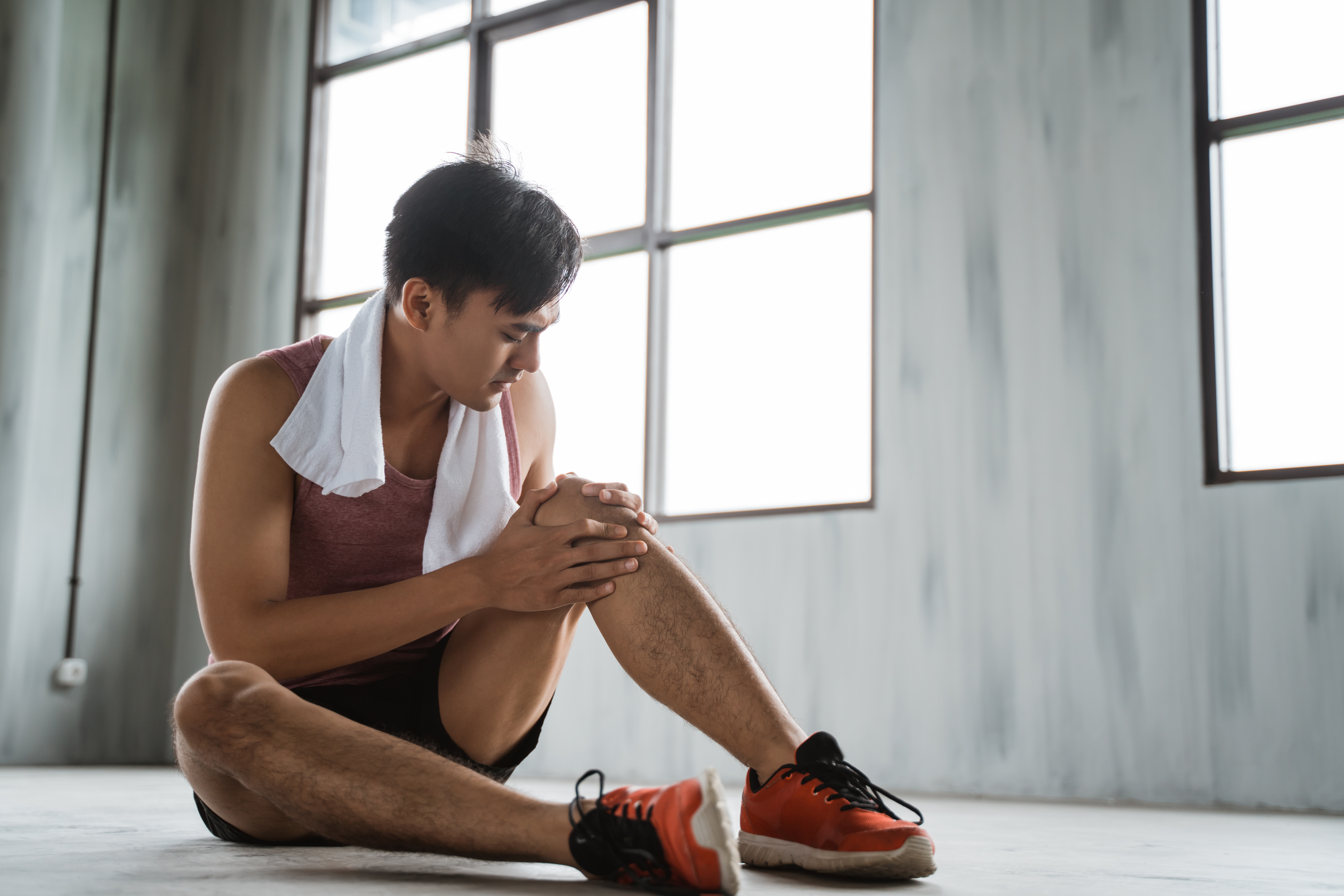 portrait of young man get knee injury while workout at the gym