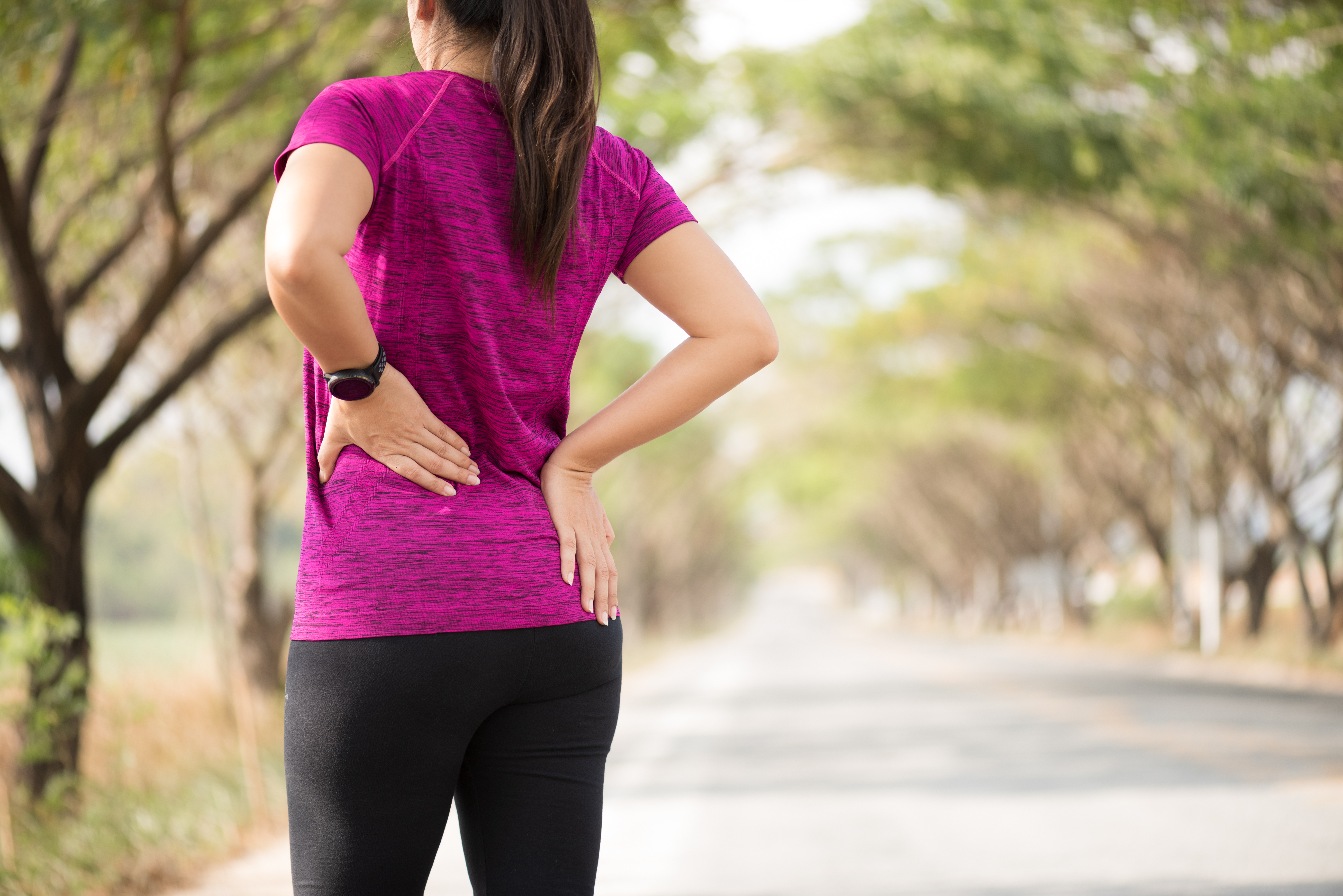 Tired Young asian Sport girl feel pain on her back and hip while exercising, health care concept.